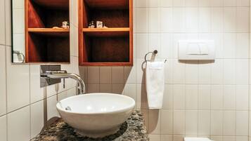 Ein Badezimmer mit einem weißen Waschbecken, einem Spiegel und einem Handtuchhalter.