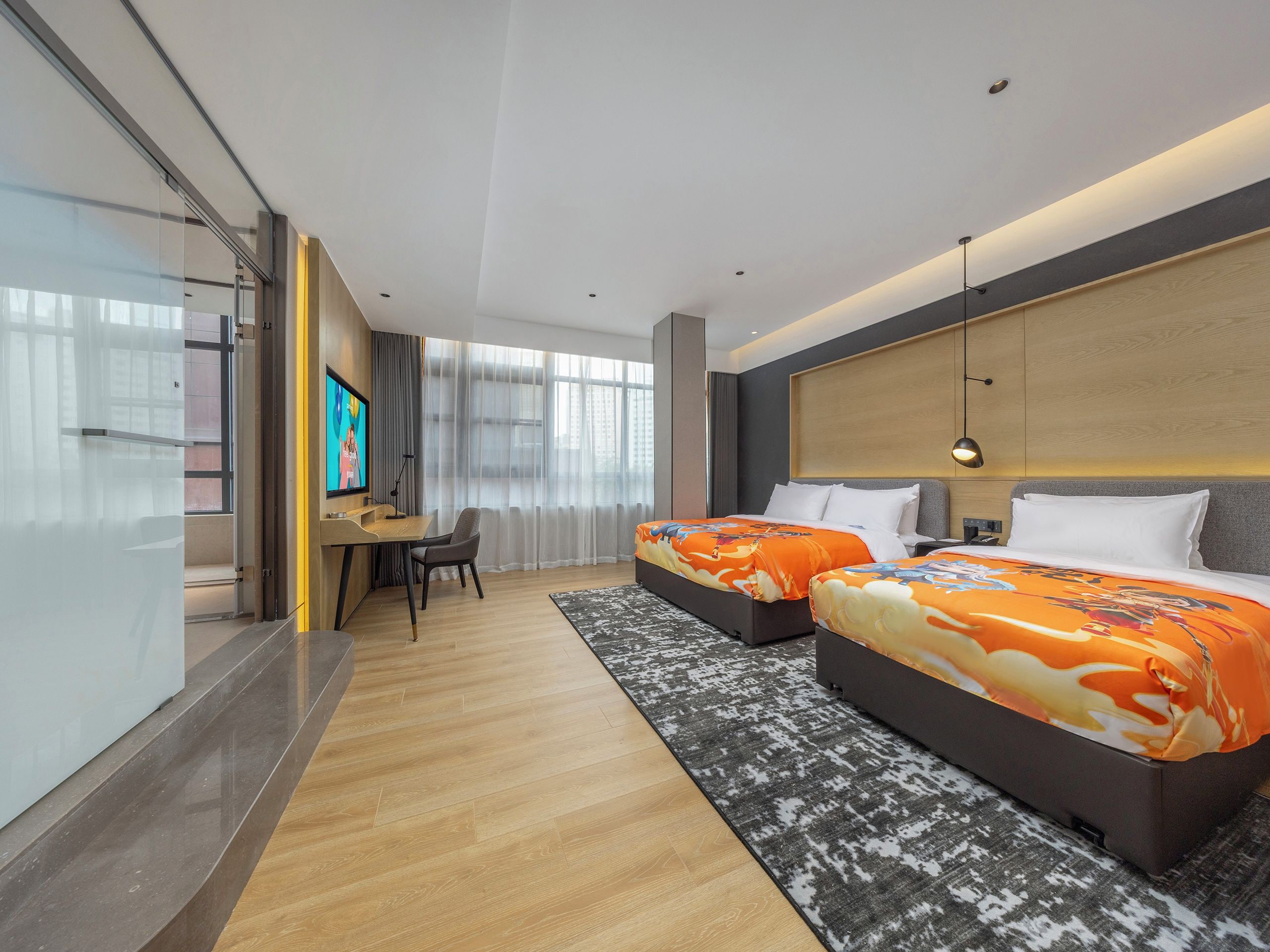 A hotel room with two beds, a desk, a TV, and a large window.