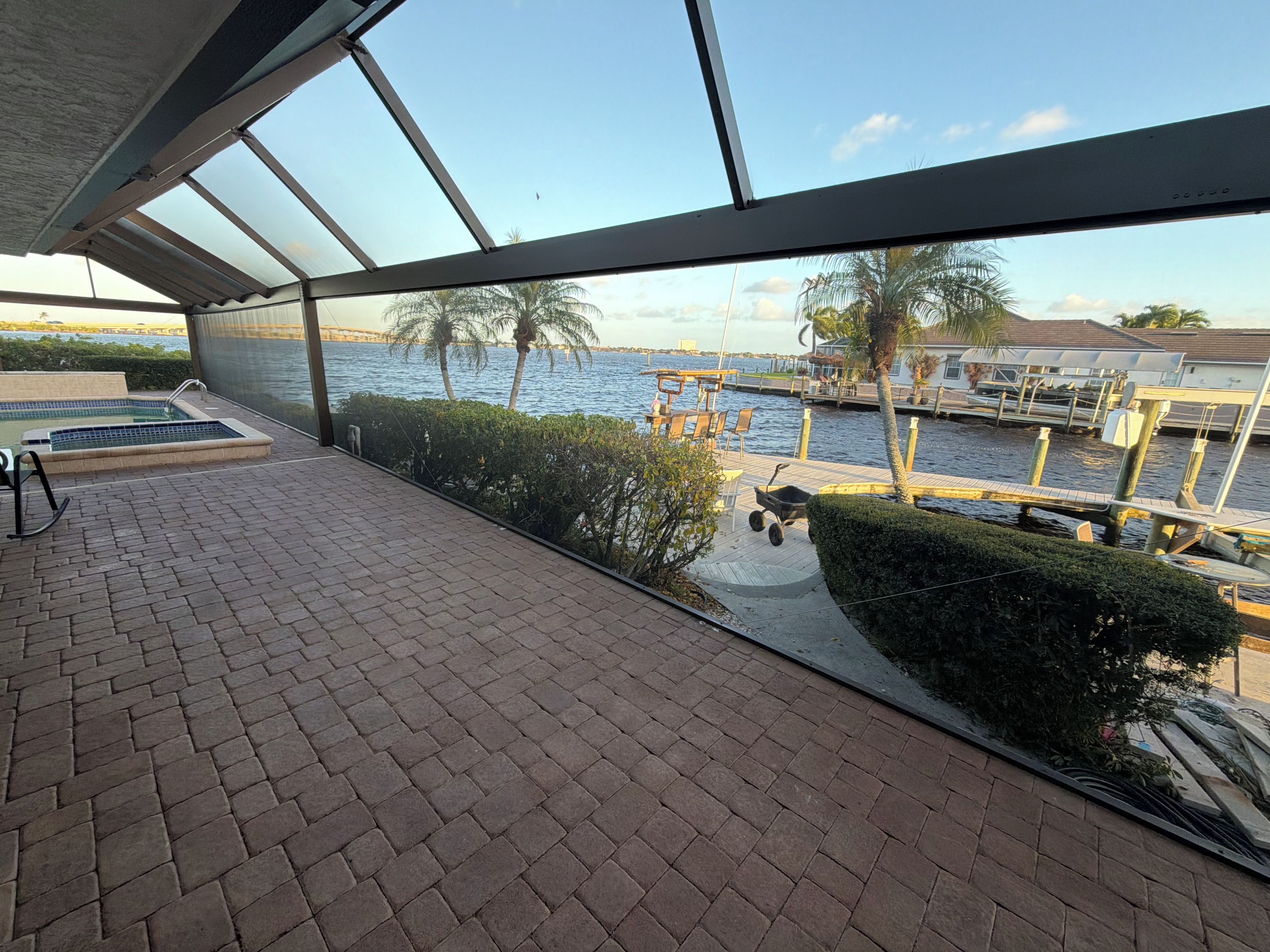 Een terras met uitzicht op een jachthaven, een zwembad en een steiger met boten.