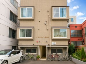 Ein mehrstöckiges Gebäude mit heller Fassade, zahlreichen Fenstern und einem gut sichtbaren Eingang.