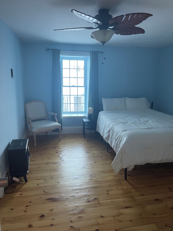 A bedroom with a bed, a chair, a desk, and a ceiling fan. - Cozy guest house in picturesque Gore Bay (Gore Bay)