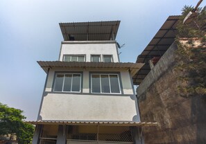 Un edificio de varios pisos con techo plano y una antena parabólica.