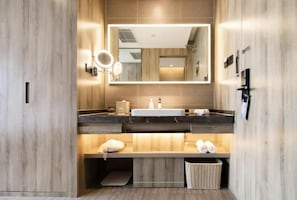 Ein modernes Badezimmer mit einem Holzkonsolenunterschrank, einem großen Spiegel und einem integrierten Waschbecken.