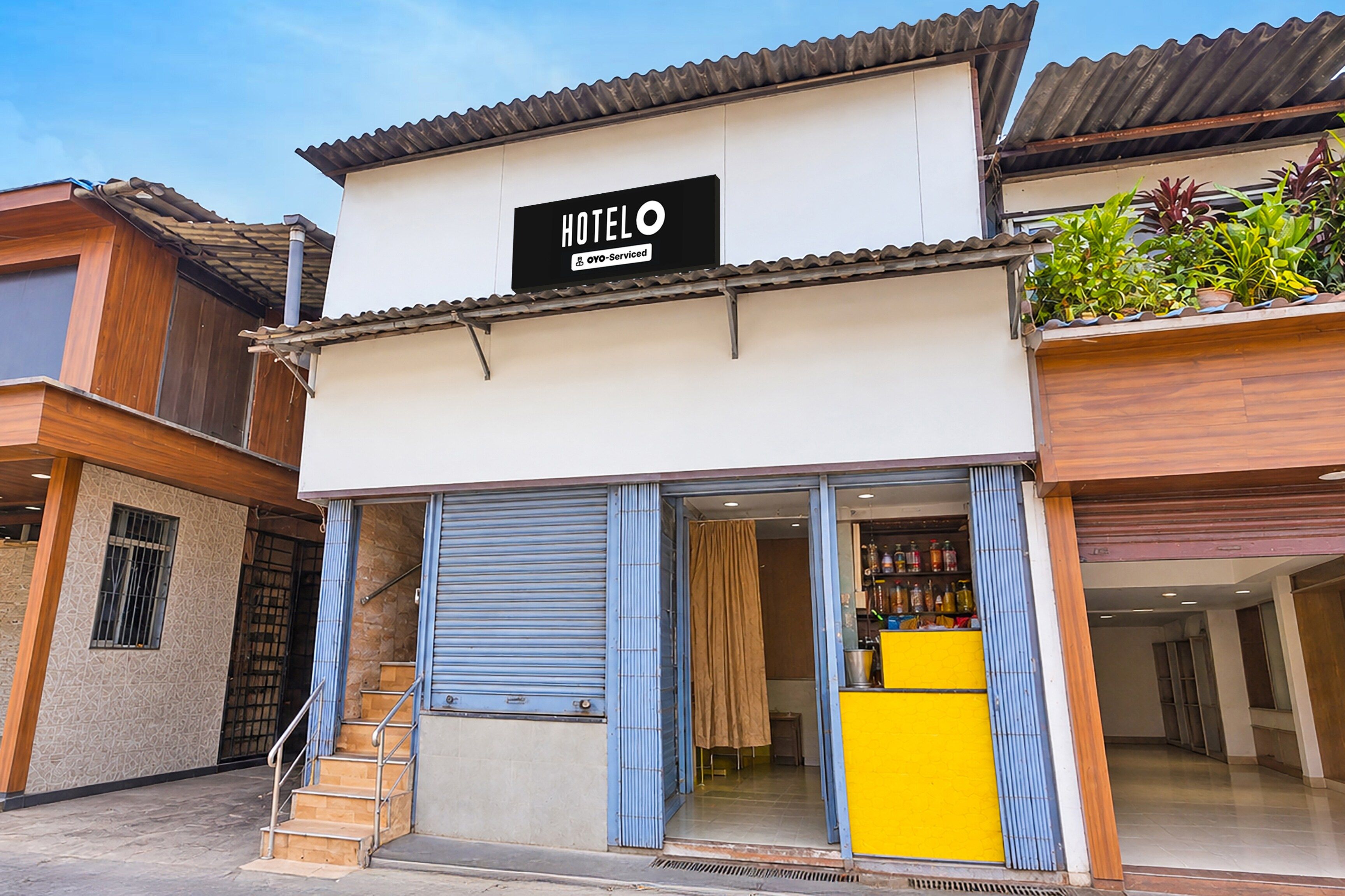 Un hotel con un letrero que dice 'HOTEL OYO-Serviced' y una escalera que lleva a la entrada.