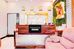 A reception desk with a sign reading 'TOWNHOUSE Company-Serviced.' - Townhouse Asalpha Near International (Mumbai)