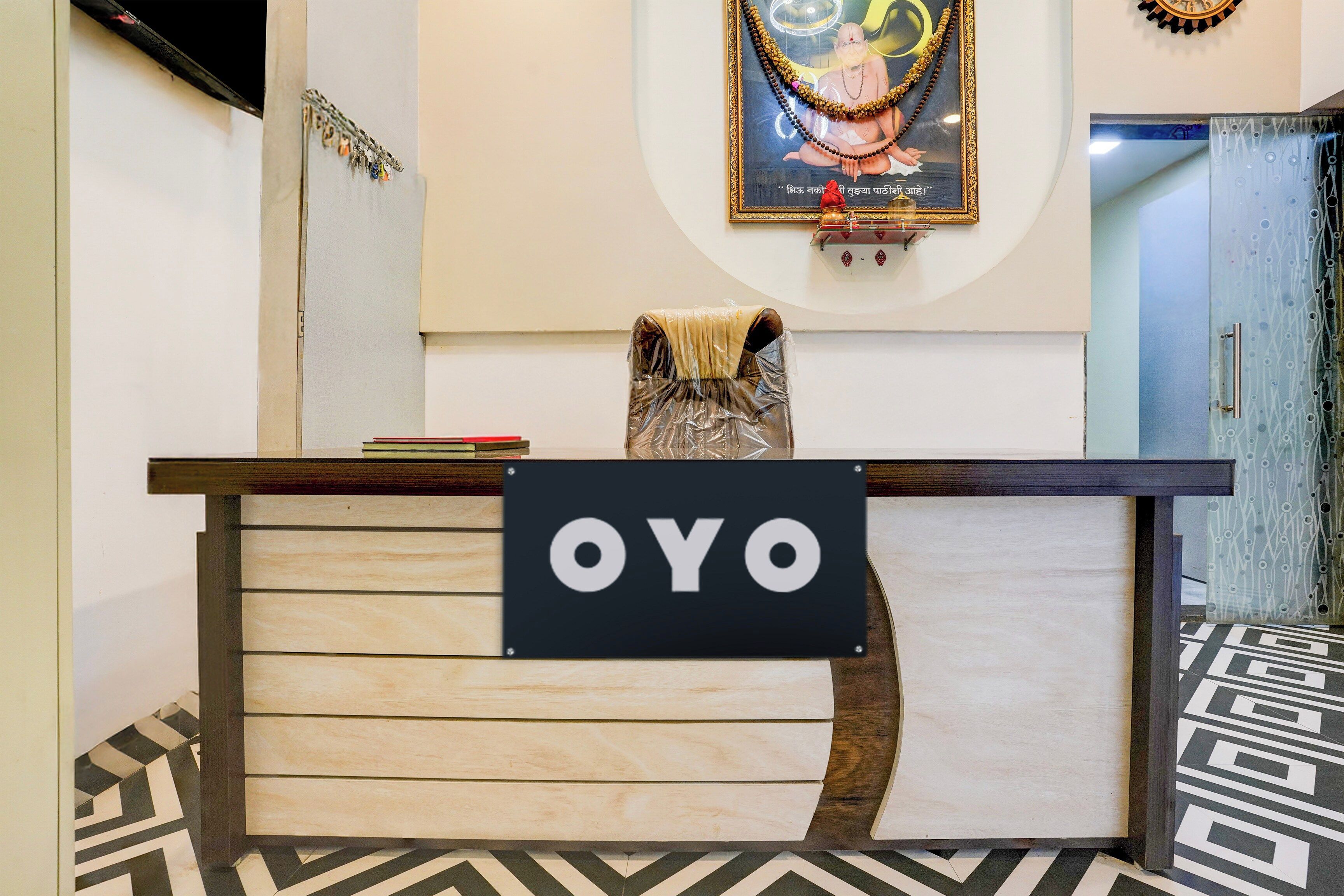 Un mostrador de recepción con un cartel que dice 'OYO' y un cuadro enmarcado encima.