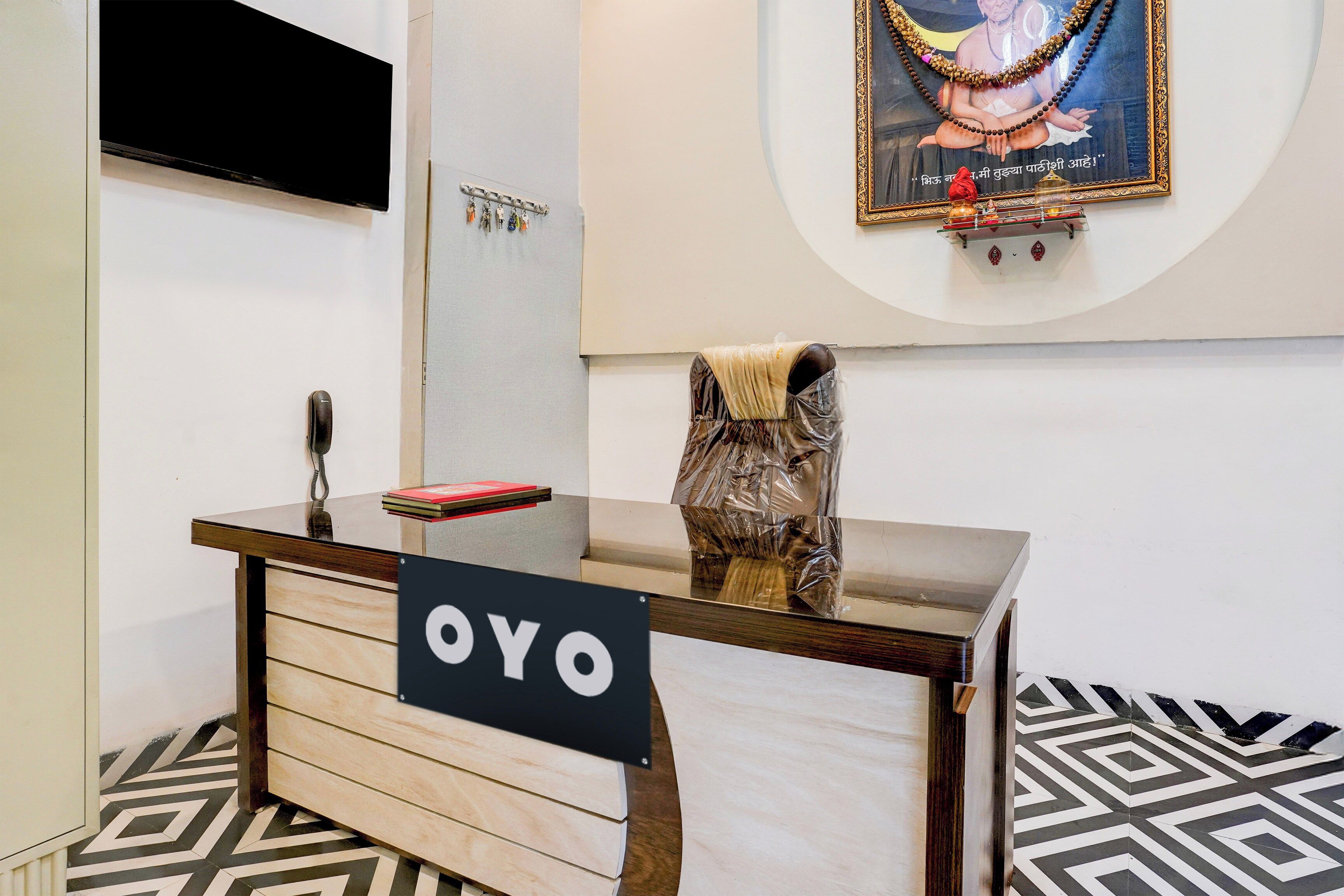 A reception desk with a sign reading 'OYO' and a framed picture above it.