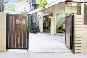 Una entrada con puerta de reja a una propiedad, con un letrero que dice 'SBA inn'.