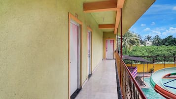 Un corridoio con porte numerate 204 e 201, che conduce a un balcone con piscina.