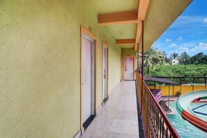 A corridor with doors numbered 204 and 201, leading to a balcony with a pool.