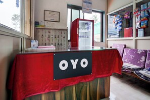 A reception desk with a sign reading 'OYO' and a calendar on the wall. - Hotel O Raj Resort (Vasai)
