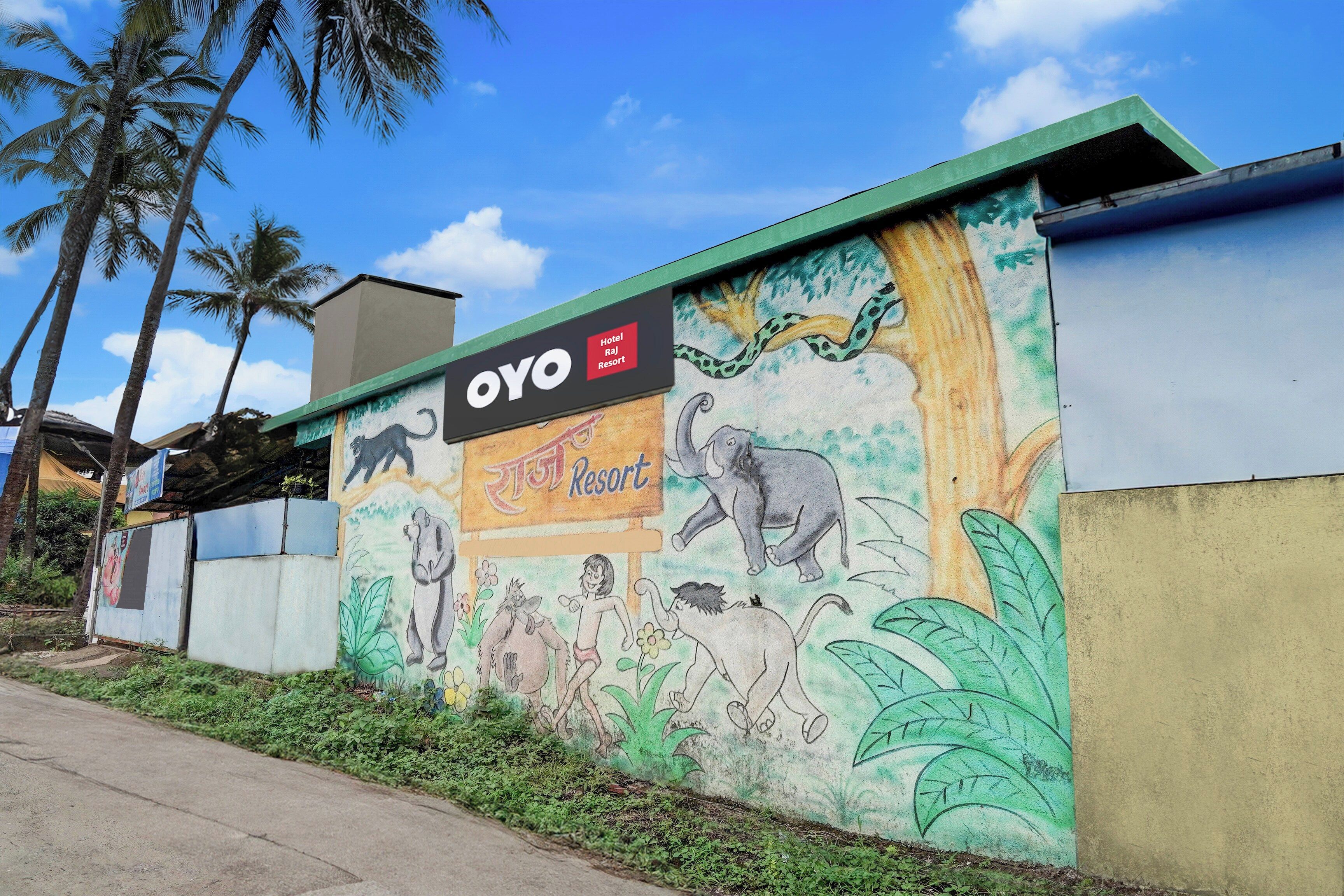 Un muro con un murale di animali selvatici e il testo 'OYO Hotel Raj Resort'.