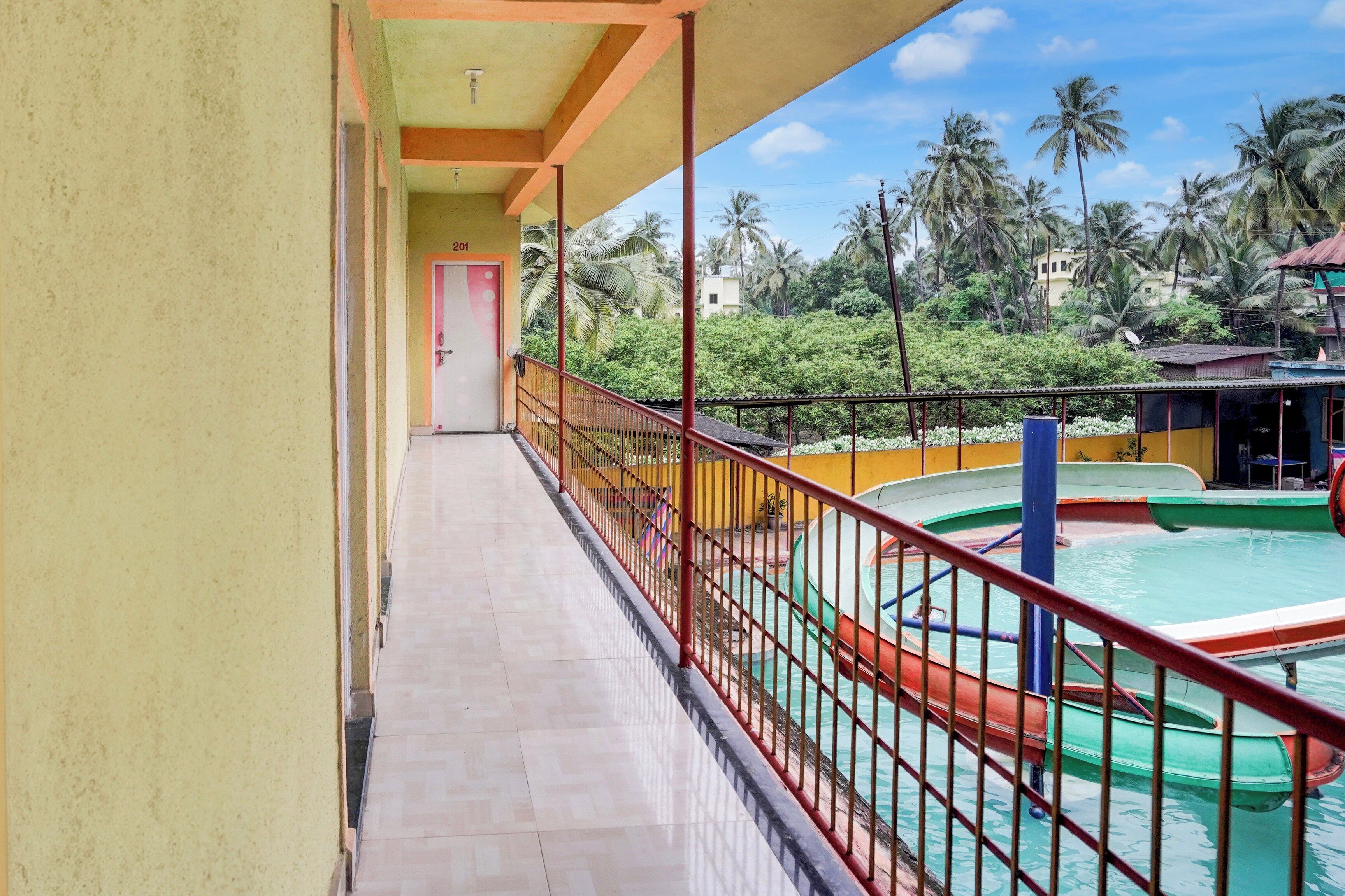 A balcony with a view of a pool and palm trees.