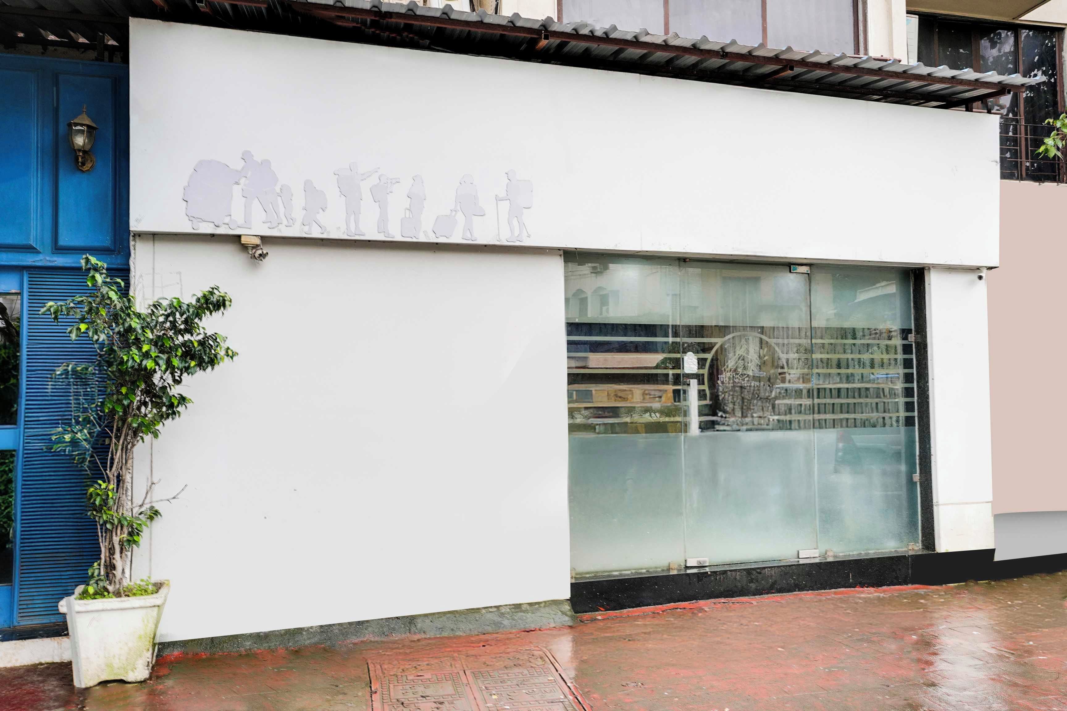 A building facade with a white wall and a large glass window.