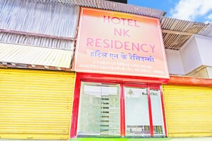 Un letrero de hotel con el nombre 'HOTEL NK RESIDENCY' y detalles de la dirección.