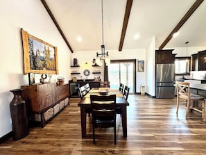 Eine geräumige Küche mit Essbereich, Holzboden und einem großen Gemälde an der Wand.