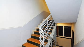 Una escalera con barandilla blanca y un rellano en la esquina.