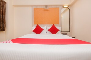 A hotel room with a bed, a large mirror, and a wall-mounted light fixture. - Hotel O Solitaire (Mumbai)