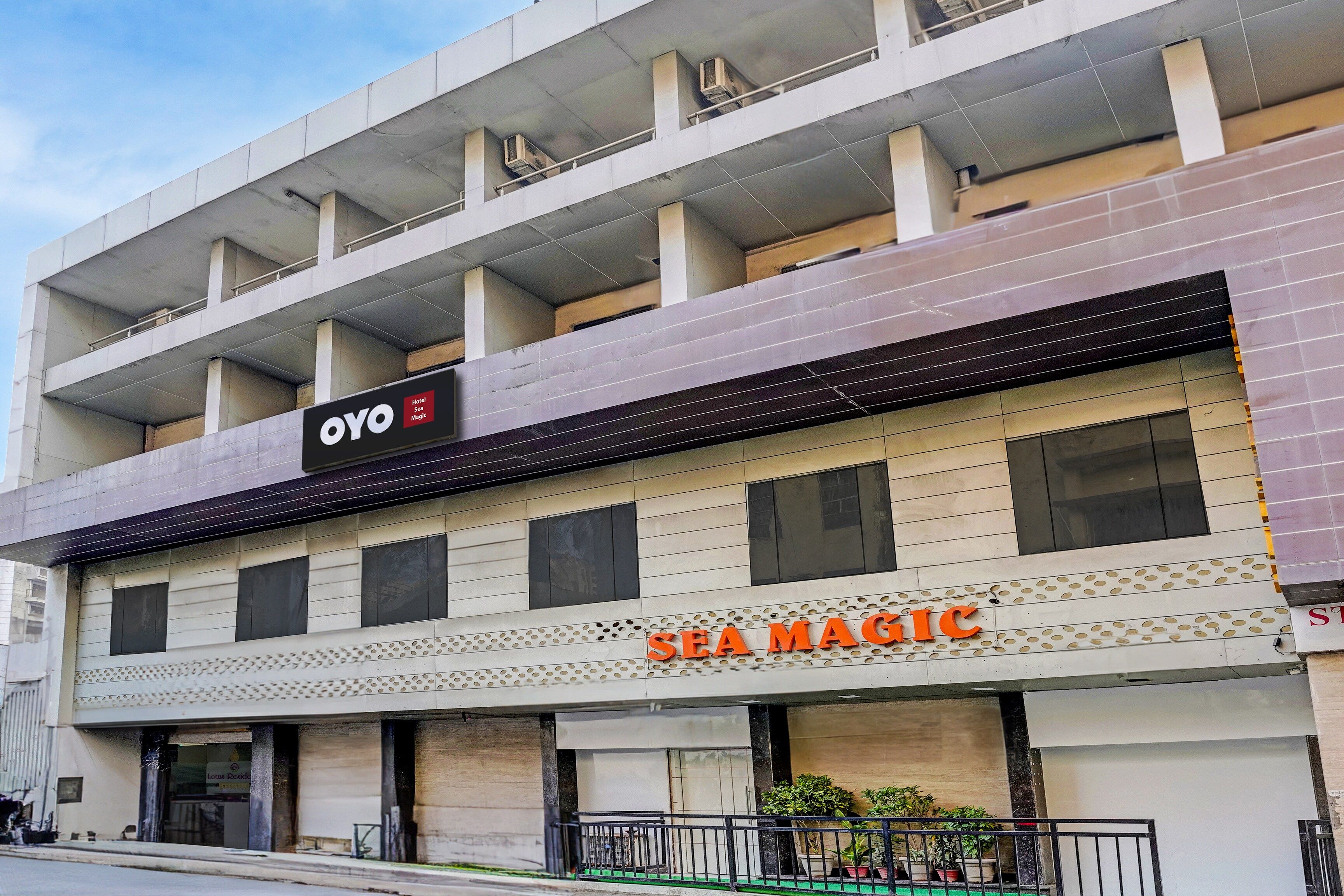 A hotel with a sign for 'OYO Hotel Sea Magic' and 'SEA MAGIC' on the facade.