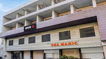 A hotel with a sign for 'OYO Hotel Sea Magic' and 'SEA MAGIC' on the facade.
