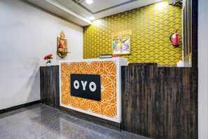 A reception desk with a geometric pattern and the name 'OYO' on it.
