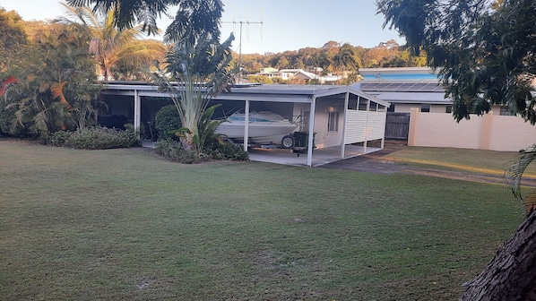 A house with a covered outdoor area, a boat on a trailer, and a grassy yard. - Walk to Beach Spacious yard for boats or 4x4 (Rainbow Beach)