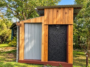 A wooden structure with a corrugated metal door and a decorative panel.
