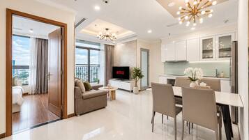 A modern living room with a sofa, TV, and dining area.
