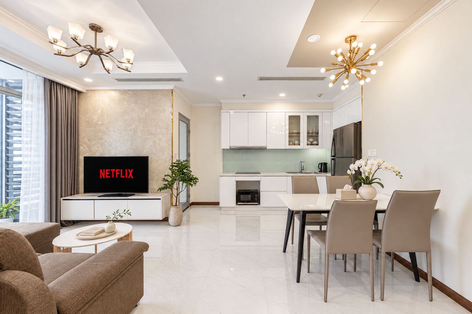 A modern living room with a flat-screen TV, a dining area with a table and chairs, a kitchen with white cabinets, and a ceiling fan.