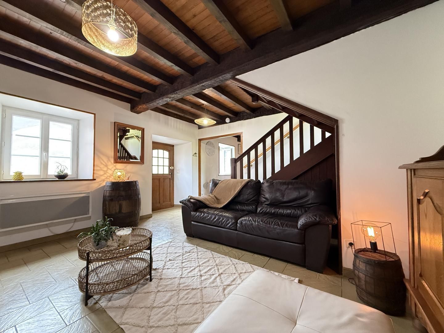 Ein großzügiges Wohnzimmer mit einer Ledersofa, einem Couchtisch und einer Treppe zu einer anderen Ebene.
