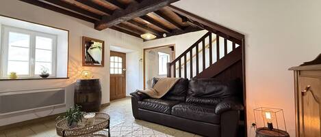 Ein großzügiges Wohnzimmer mit einer Ledersofa, einem Couchtisch und einer Treppe zu einer anderen Ebene.