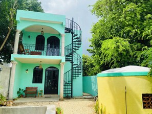 A two-story building with a spiral staircase, a balcony, and a front door with a black gate. - Minutes to Tourist Attractions, Hospital Zone, Airport, ADO, Stores, Restaurants (Mérida)