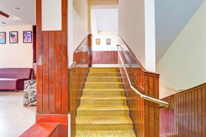 A staircase with wooden railings and a red bench in the foreground.