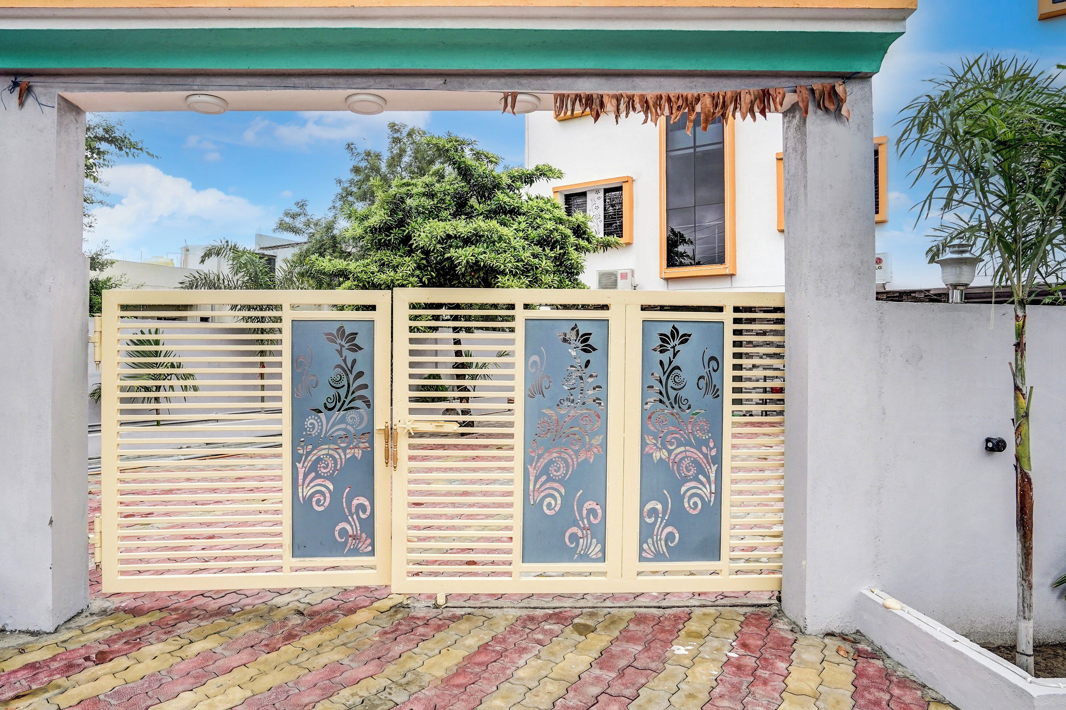 Una entrada protegida con paneles decorativos y un camino empavedado que lleva a un edificio.