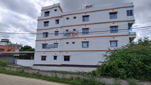 Un hotel de varios pisos con un cartel que indica habitaciones y opciones sin aire acondicionado.