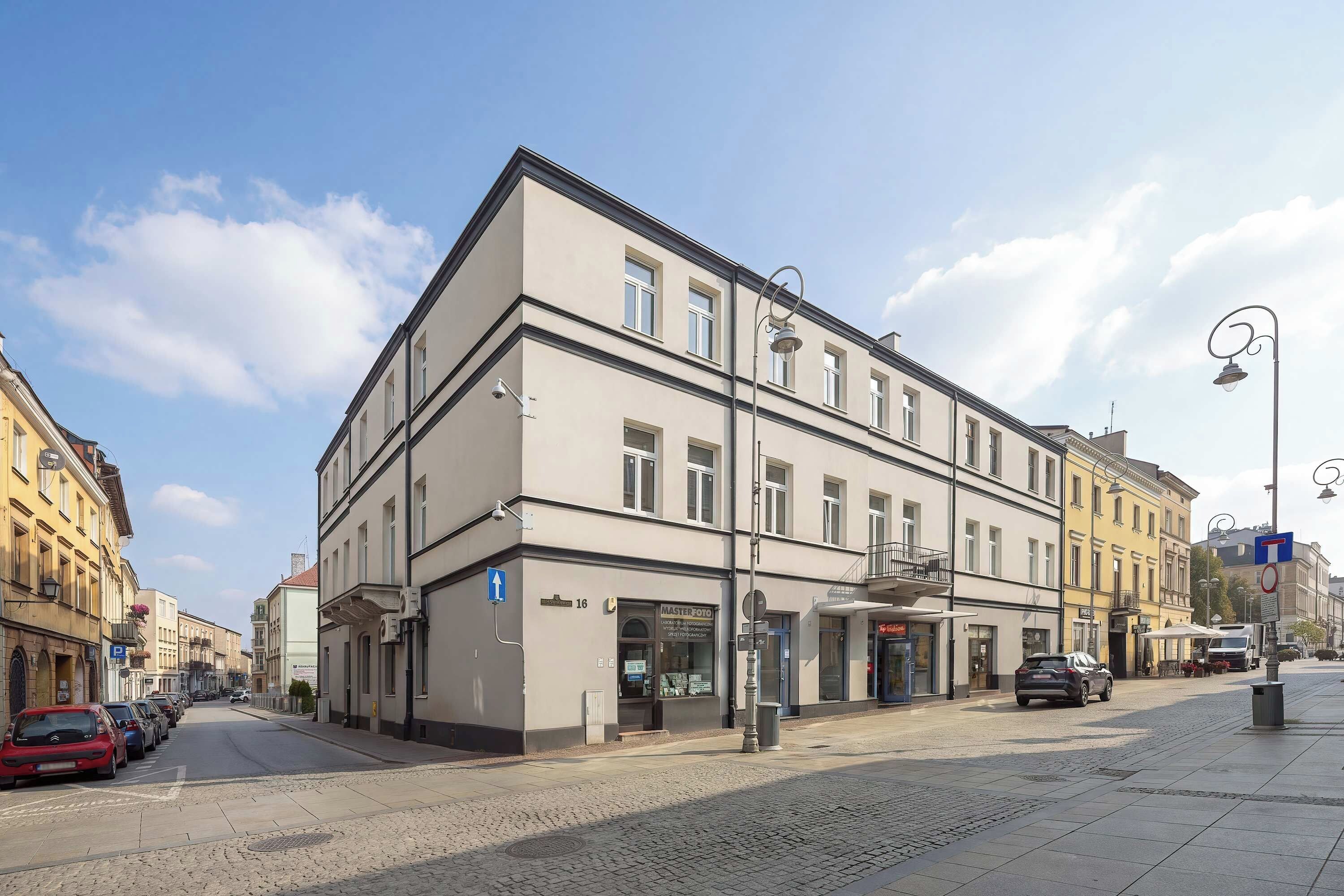 Ein mehrstöckiges Gebäude mit einem Geschäft im Erdgeschoss und einem gut sichtbaren Eingang.