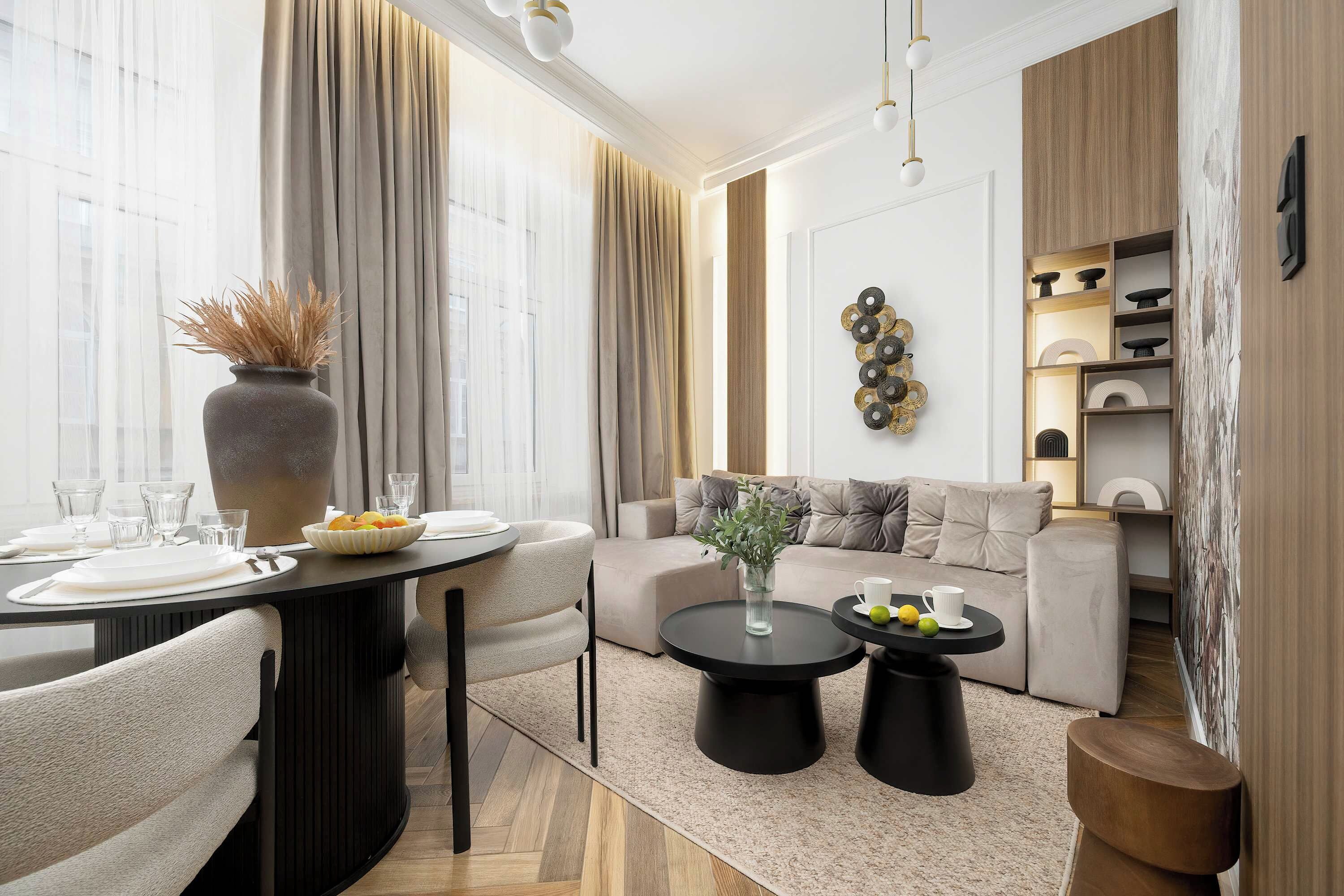 Ein modernes Wohnzimmer mit Essbereich, ausgestattet mit einem runden Tisch, Sofas und einem Couchtisch.
