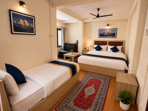 A hotel room with two single beds, a sofa, a TV, a desk, and a ceiling fan. - Hotel Sherpa Soul (Kathmandu)