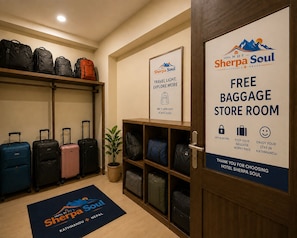 A hotel lobby with a free baggage store room, a travel light sign, and a Sherpa Soul logo. - Hotel Sherpa Soul (Kathmandu)