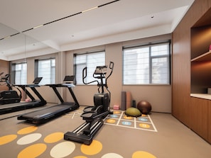 A fitness room with treadmills, an elliptical, and a mat with numbered tiles. - UrCove by Hyatt Lanzhou Dongfanghong (Lanzhou)