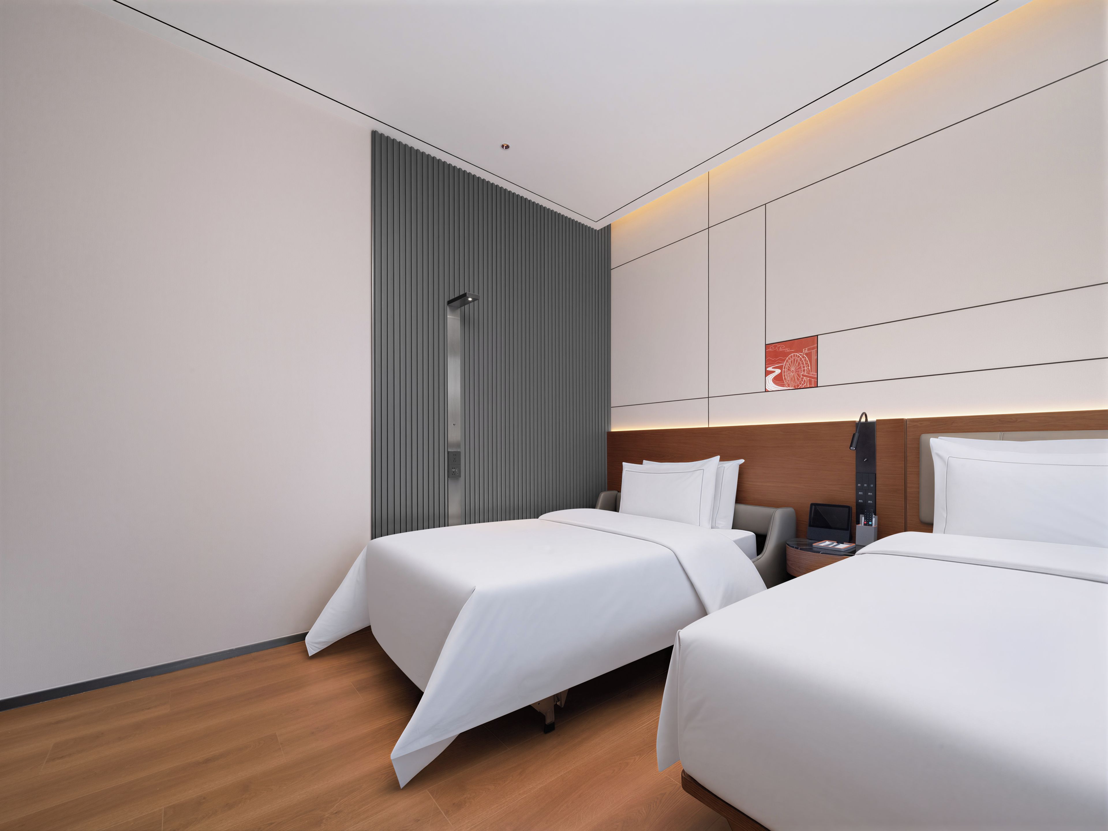 Habitación de hotel moderna con dos camas, ducha y panel de control en la pared.