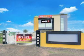 Un hotel amb un cartell ben visible que diu 'HOTEL SPACE INN' i 'OYO Hotel Space Inn', indicant disponibilitat de habitacions sense aire condicionat.