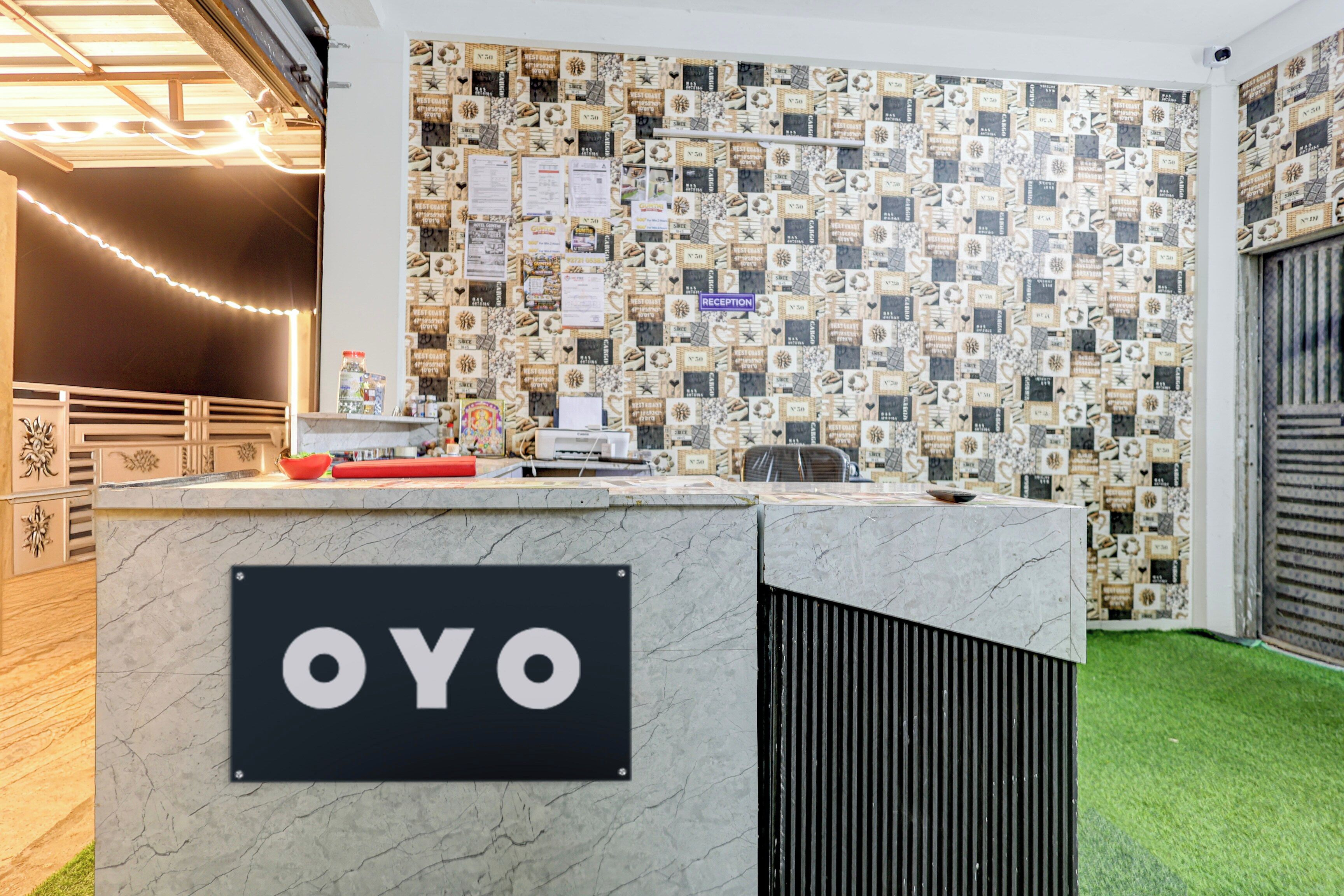 A reception desk with a sign reading 'OYO' and a wall decorated with vintage-style postcards.