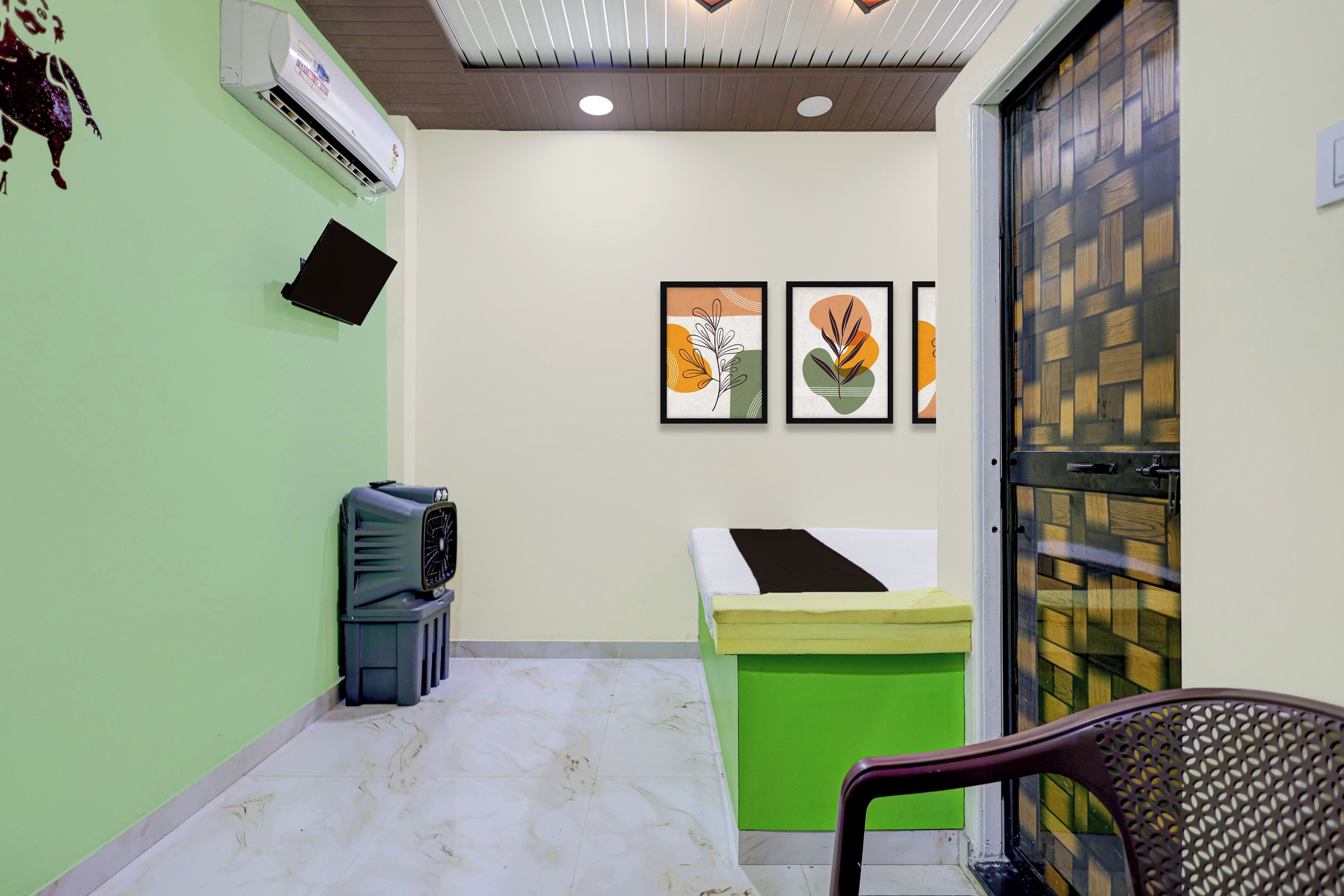 Un espace d’accueil agrémenté d’un mur végétal, d’un comptoir de réception, d’une chaise et d’œuvres d’art encadrées accrochées au mur.