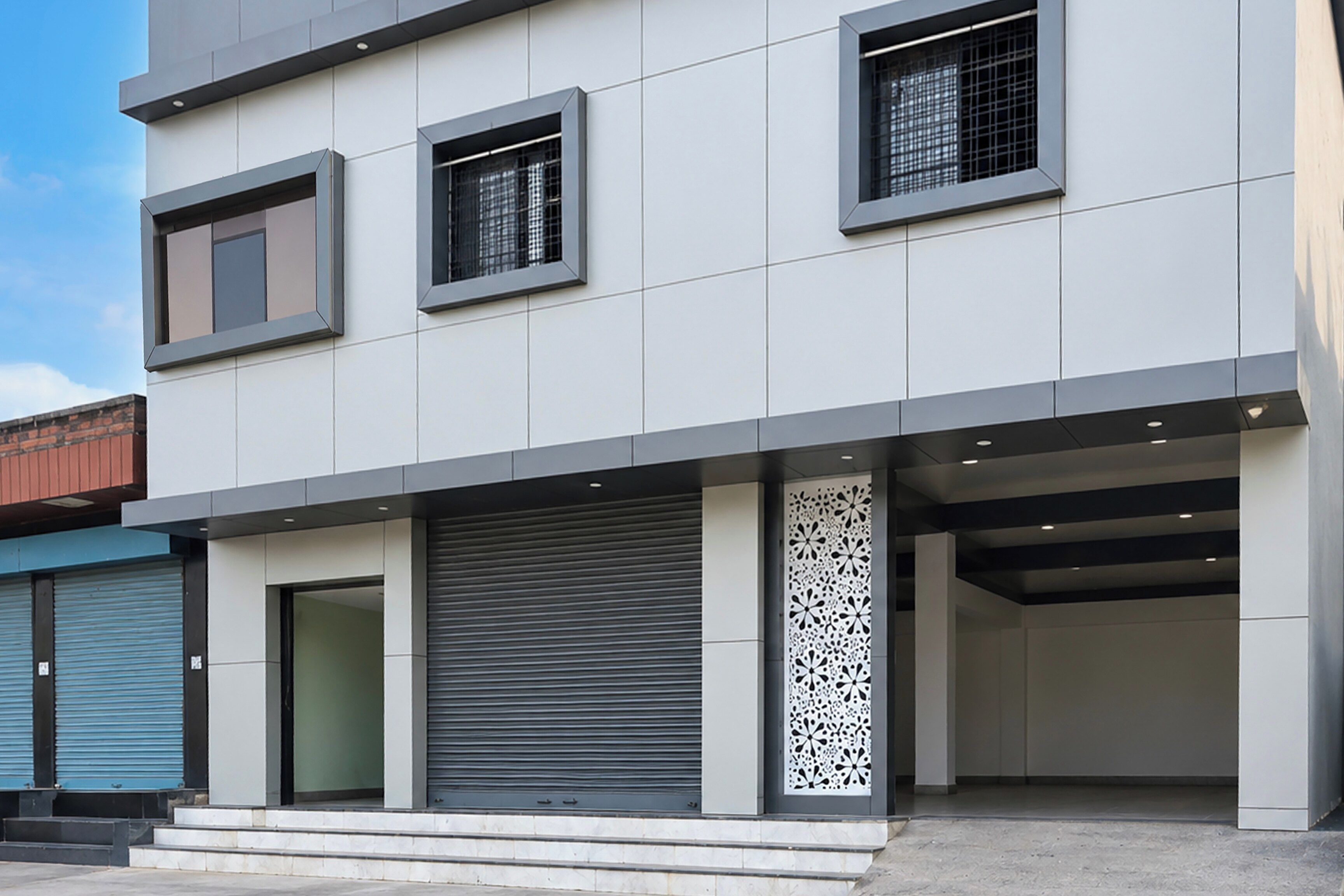 Um edifício moderno com telhado plano, janelas amplas e entrada para garagem.