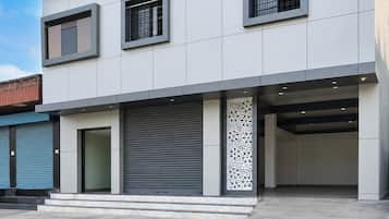 Um edifício moderno com telhado plano, janelas amplas e entrada para garagem.