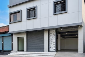 A modern building with a flat roof, large windows, and a garage entrance.