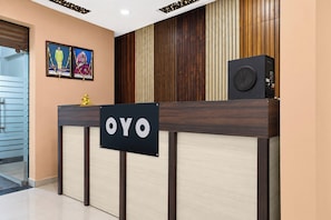 Una recepción con un letrero que dice 'OYO' y un altavoz encima.