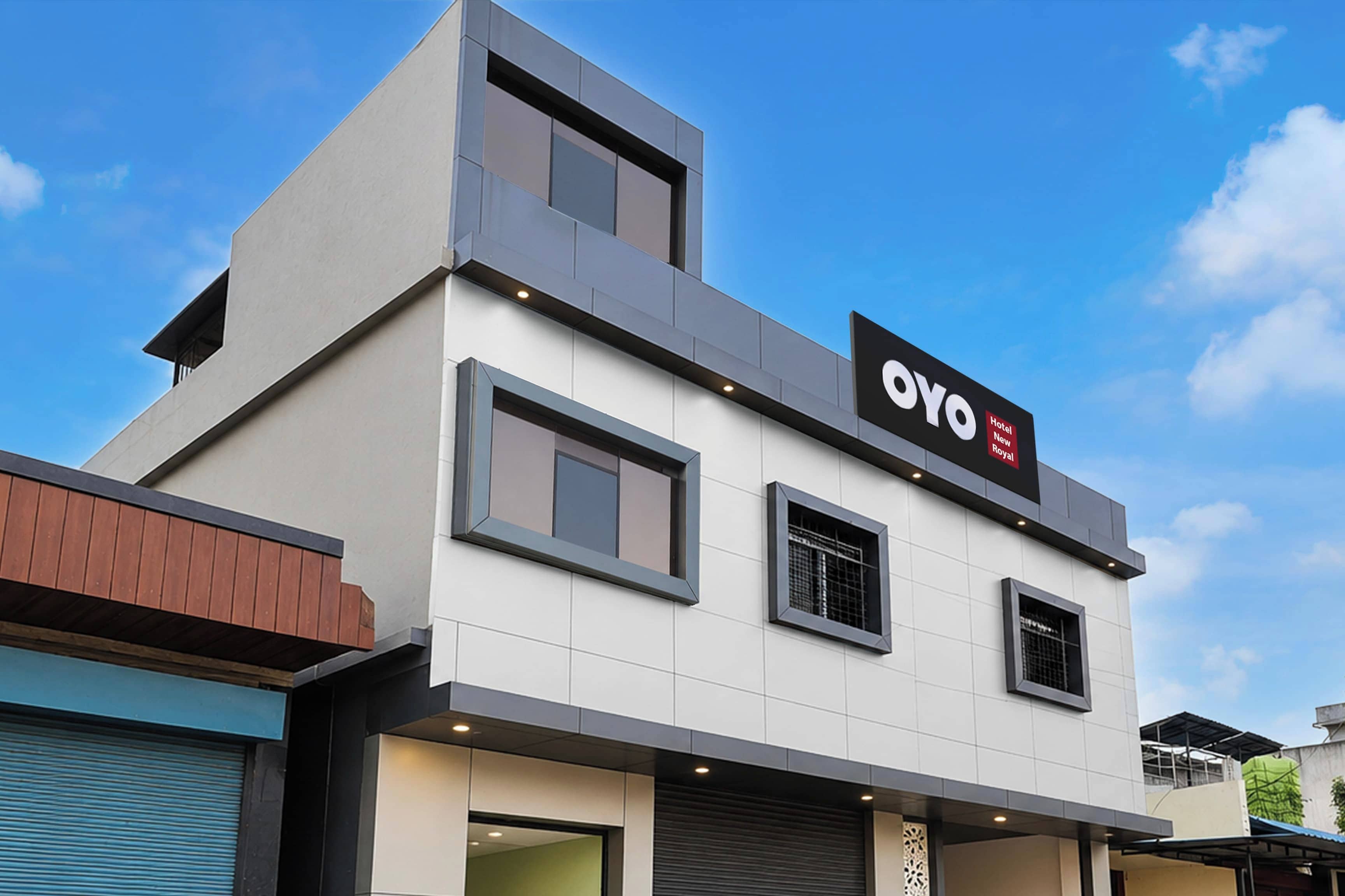 Un edifici d'hotel modern amb un cartell prominent que diu 'OYO Hotel New Royal'.