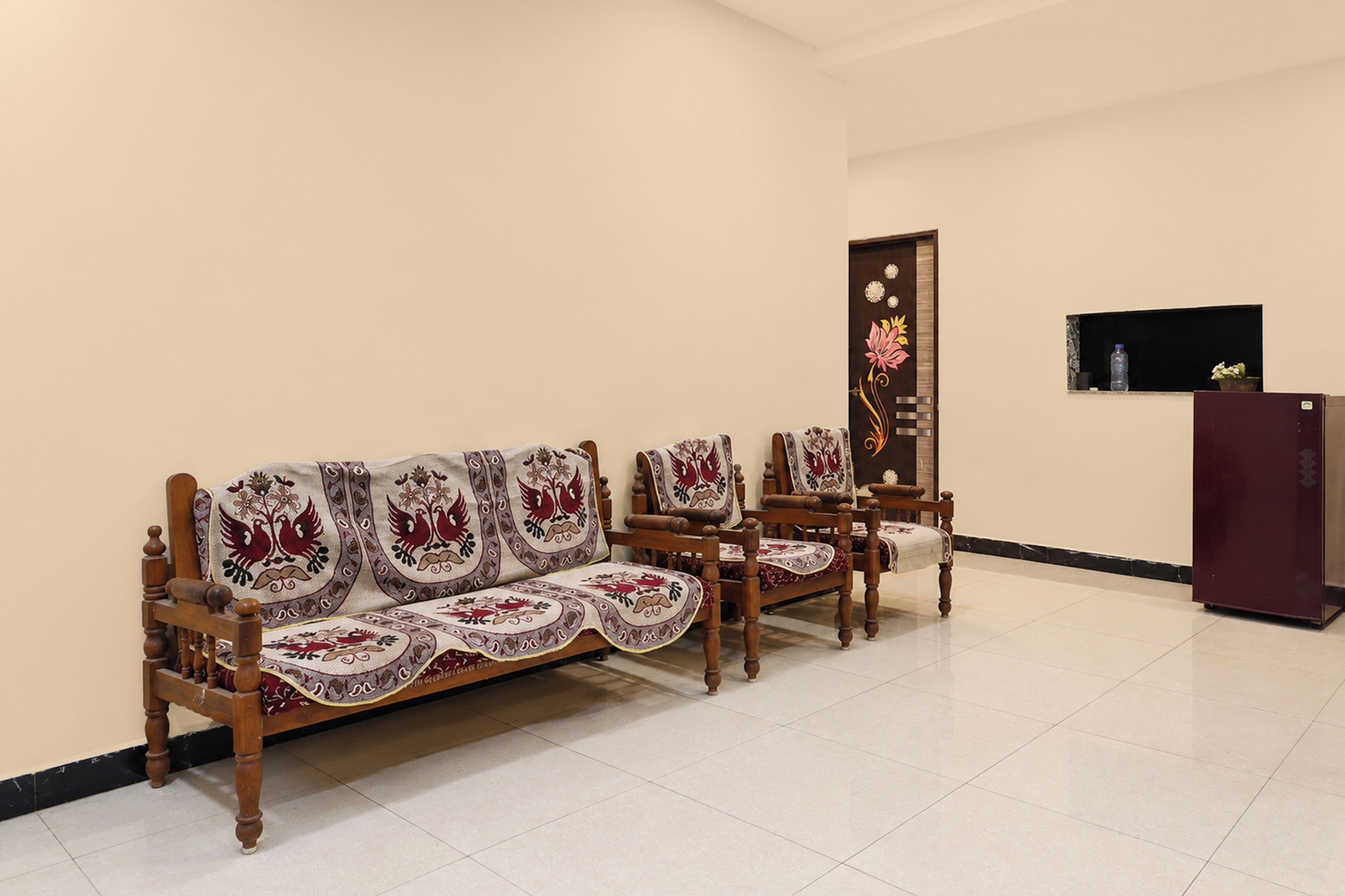 A room with a sofa set, chairs, a cabinet, and a television.
